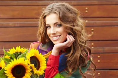 Woman Long Wavy Hair Smiles Nature Wallpaper 4K 4550x3000 A, Beautiful, Woman, With, Long, Wavy, Hair, Smiles, Brightly, Holding, Vibrant, Sunflowers, Brown, Ultrawide, 4k