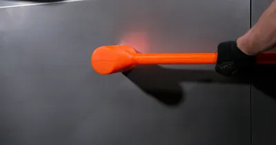 Hand Black Glove Holds Orange Technology Wallpaper 4K 4000x2109 A, Hand, With, Black, Glove, Holds, An, Orange, Tool, Against, Sleek, Surface, Red, Brown, Ultrawide, 4k