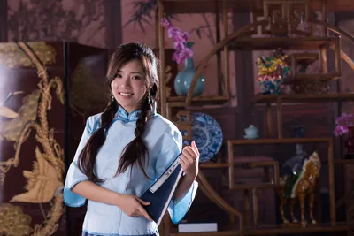 Smiling Taiwanese Woman Abstract Wallpaper 4K 7360x4912 A, Smiling, Taiwanese, Woman, In, Traditional, Attire, Holds, Copybook, Beside, Vase, Orchids, Gray, Landscape, 4k