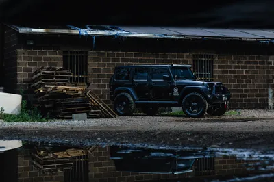 Black Jeep Wrangler Black/Dark Wallpaper 4K 2500x1667 A, Black, Jeep, Wrangler, Suv, Parked, Next, To, Rustic, Building, Surrounded, Stacked, Gray, Brown, Landscape, Full HD