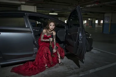 Tattooed Brunette Woman Cars Wallpaper 4K 2048x1367 A, Tattooed, Brunette, Woman, In, Striking, Red, Dress, Sits, Car, Holding, Assault, Brown, Gray, Landscape, Full HD